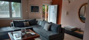 uma sala de estar com um sofá azul e uma mesa em Airport Friendly House 1 em Artemida