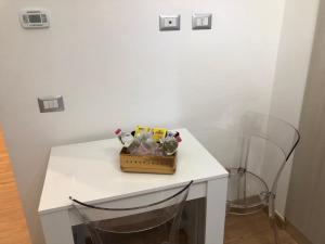 una mesa blanca con una cesta de animales de peluche. en RaffaelloElegante appartamento ideale casa vacanze affari, en Milán