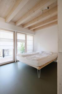 ein großes Bett in einem Zimmer mit Fenstern in der Unterkunft SCHICK und LUFTIG im Herzen von Linz in Linz