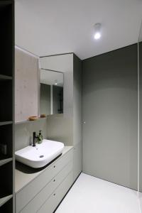 a bathroom with a white sink and a mirror at SCHICK und LUFTIG im Herzen von Linz in Linz