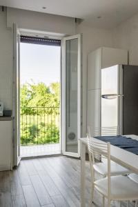 a kitchen with a refrigerator and a table with chairs at Bologna Accommodation - Fiera - Self checkin - 24h in Bologna