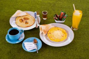 a table with two plates of food and a cup of coffee at Maringo cottage in Gili Trawangan