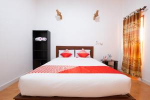 a bedroom with a large bed with red and white pillows at Maringo cottage in Gili Trawangan