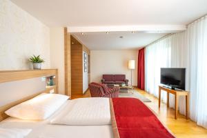 a hotel room with a bed and a television at Hotel Stadt Freiburg in Freiburg im Breisgau