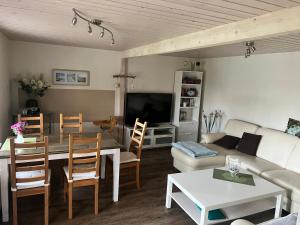 ein Wohnzimmer mit einem Sofa, einem Tisch und einem TV in der Unterkunft Ferienhaus Kira in Boltenhagen