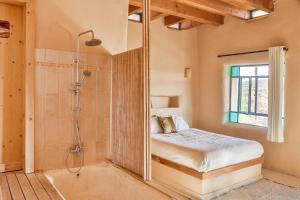 a bedroom with a shower and a bed in a room at Midbara in Zuqim
