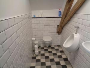 y baño con aseo, urinario y lavamanos. en appartement met 5 slaapkamers, en Moerstraten