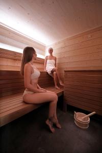 Dos mujeres están sentadas en una sauna. en Schätzlhof OHG, en Ruderting