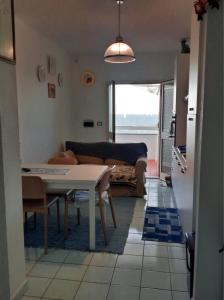 a kitchen and living room with a table and a couch at Fronte mare in Castelsardo