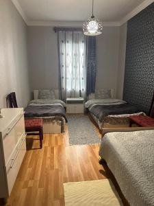 a bedroom with three beds and a chandelier at Guest house Amazon in Kutaisi