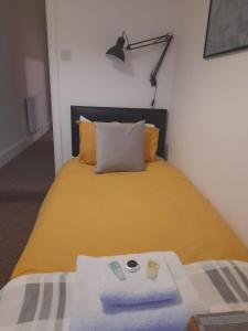 a bedroom with a yellow bed with a lamp at Colville House in Lincolnshire