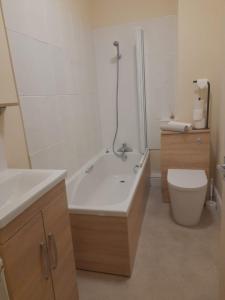 ein Badezimmer mit einer Badewanne, einem WC und einem Waschbecken in der Unterkunft Colville House in Lincolnshire