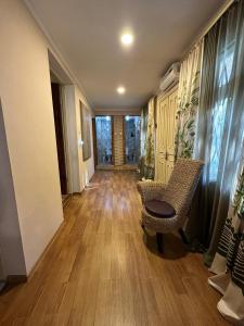 a hallway with a chair and wooden flooring in a house at Guest house Amazon in Kutaisi