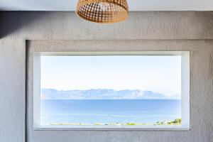 a window with a picture of the ocean at WHITE DONKEY Hotel in Chrani