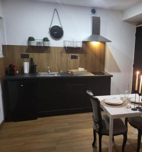 a kitchen with a sink and a table with chairs at Cosy Corner - Appartement spa - Jacuzzi in Marsannay-la-Côte