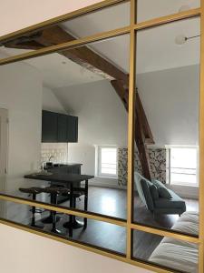 espejo que refleja una sala de estar con mesa y silla en Centre de Provins : superbe appartement neuf, en Provins