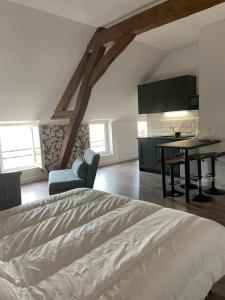 a bedroom with a bed and a table and a kitchen at Centre de Provins : superbe appartement neuf in Provins