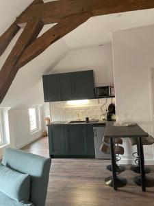 a kitchen with green cabinets and a table in a room at Centre de Provins : superbe appartement neuf in Provins