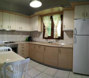 a kitchen with white cabinets and a white refrigerator at House Evristhenis 2 in Toroni