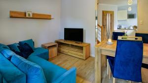 a living room with a blue couch and a television at U Gruszków - domek pod Chojnikiem in Jelenia Góra