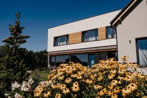 una casa con flores amarillas delante de ella en Hotel Maralák en Kunčice pod Ondřejníkem