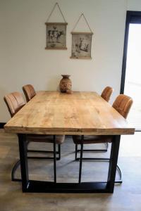 uma mesa de madeira com cadeiras num quarto em Vakantiewoning 'De Eijk' em Doornspijk