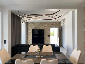 a dining room with a black table and white chairs at Villa Sun and Sea in Trogir