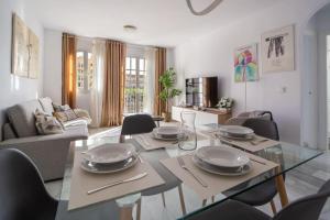 a living room with a glass table and chairs at Cozy central apartment with FREE parking in Málaga