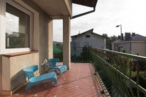 two blue chairs on a balcony with a window at Apartament na Fatimskiej in Krakow