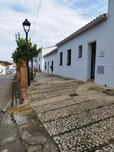 uma rua de calçada ao lado de um edifício branco em Las Tobas em Puerto-Moral