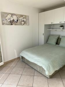 1 dormitorio con 1 cama y una pintura en la pared en Cap d.Azur, en Roquebrune-Cap-Martin