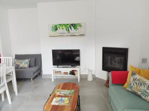 uma sala de estar com um sofá e uma televisão em Las Tobas em Puerto-Moral