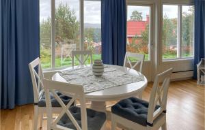 ein Esszimmer mit einem Tisch, Stühlen und Fenstern in der Unterkunft Cozy Home In Tvedestrand With House Sea View in Tvedestrand