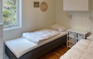 two beds in a small room with a window at Stunning Home In Tvedestrand With 3 Bedrooms And Wifi in Tvedestrand