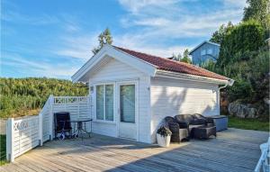 a small white shed on a wooden deck at Stunning Home In Tvedestrand With 3 Bedrooms And Wifi in Tvedestrand