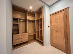 a walk in closet with wooden cabinets and a wooden door at Mariaddo homes in Accra