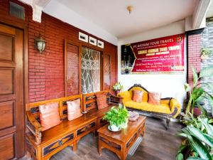 um alpendre de um restaurante com sofás e mesas em OYO 91827 Tutus Homestay Syariah em Bugul