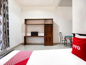 um quarto de hotel com uma cama e uma secretária em OYO 91827 Tutus Homestay Syariah em Bugul