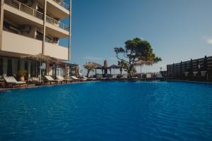 uma grande piscina com cadeiras e um edifício em Mati Hotel em Mati