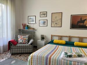 ein Schlafzimmer mit einem Bett und einem Stuhl in der Unterkunft Bnbook Garden View Villa in Sesto Calende