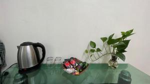 a tea kettle and a vase on a glass table at Green Riders House in Cao Bằng