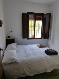 um quarto com uma grande cama branca e uma janela em Las Tobas em Puerto-Moral