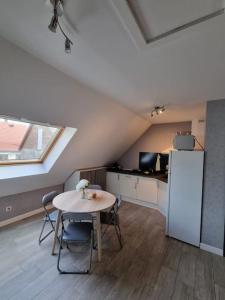 a kitchen with a table and a refrigerator in a room at Studio de la Demi Lune in Plobsheim