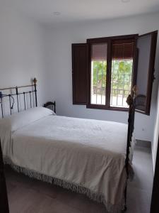 um quarto com uma cama e duas janelas em Las Tobas em Puerto-Moral