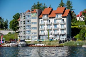 un bâtiment sur l'eau avec des bateaux devant lui dans l'établissement Ach Mazury, à Mikołajki