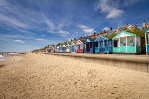 una fila de casas coloridas en la playa en The Shiny Pebble, 5* ground floor.Coastal retreat., en Southwold