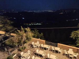 een groep stoelen die 's nachts op een balkon zitten bij U'Giruni in San Donato di Ninea