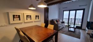a dining room with a table and a couch at APART-SKY A PIE DE PISTAS PARA 6PERSONAS - LA MOLINA ESTACIÓN in La Molina