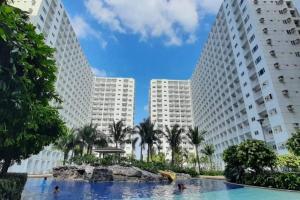 a swimming pool in front of two tall buildings at Luxury Seaside Sunset view at the Shore Mall of Asia in Manila