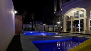 a swimming pool in front of a building at night at نزل خيال للشقق المخدومه in Jazan